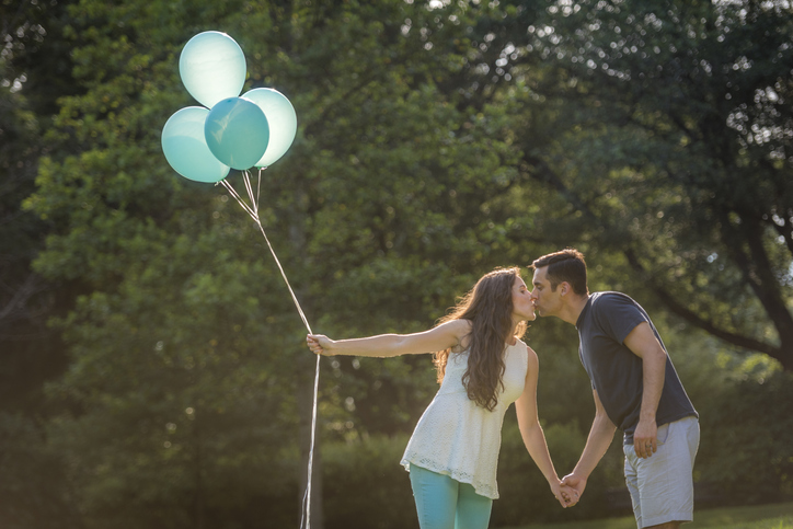 Hispanic couple with gender reveal balloons