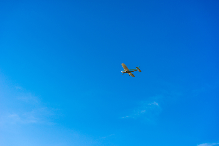 Small aircraft fly over blue sky