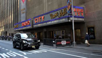 Black car driving by the Radio City Music Hall, Rockfeller Center, Midtown Manhattan, New York City
