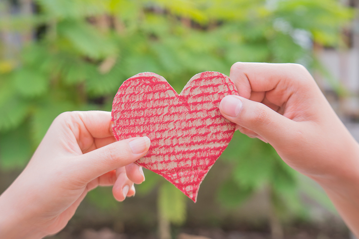 Close-Up Of Hand Holding Heart Shape Against Blurred Background