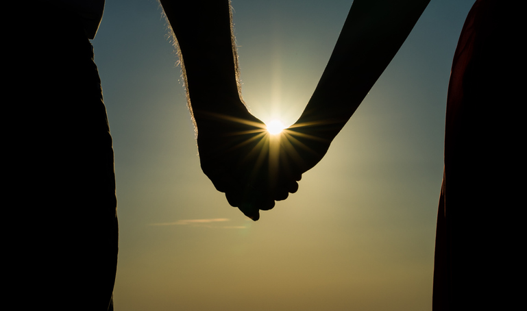 Midsection Of Silhouette Couple Holding Hands Against Sky During Sunset