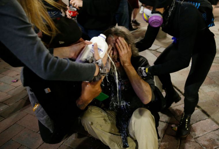 A man who was pepper sprayed by police has milk poured on his face in Boston.