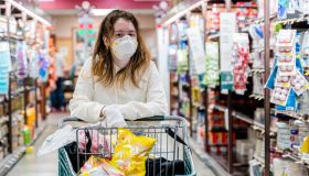 Safe shopping practice during a viral pandemic outbreak. A young girl wearing a protective mask and gloves in a grocery store.