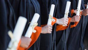 Multi-ethnic teenage graduates in cap and gown