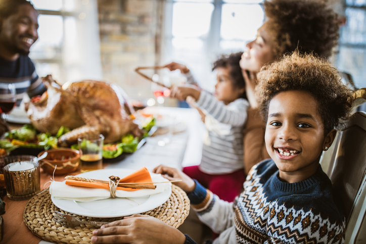 Happy black girl during Thanksgiving lunch with her family.