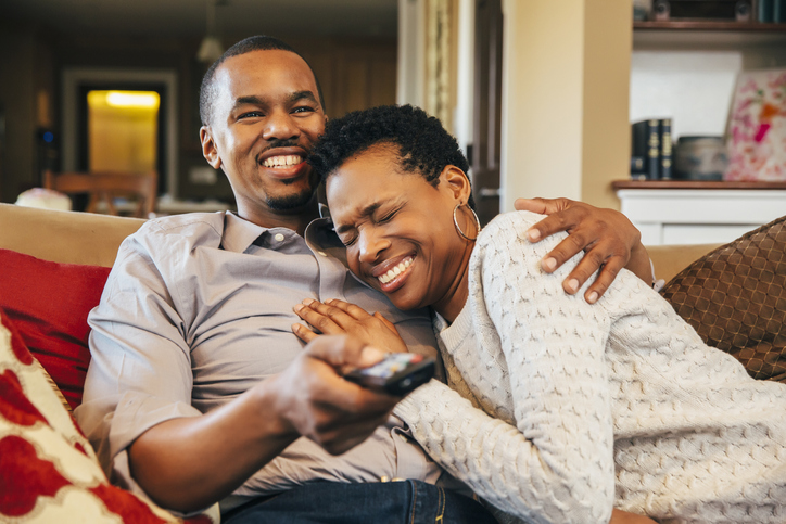 Black couple watching television on sofa