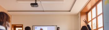 High school teacher giving a lecture, using smart board
