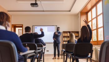 High school teacher giving a lecture, using smart board