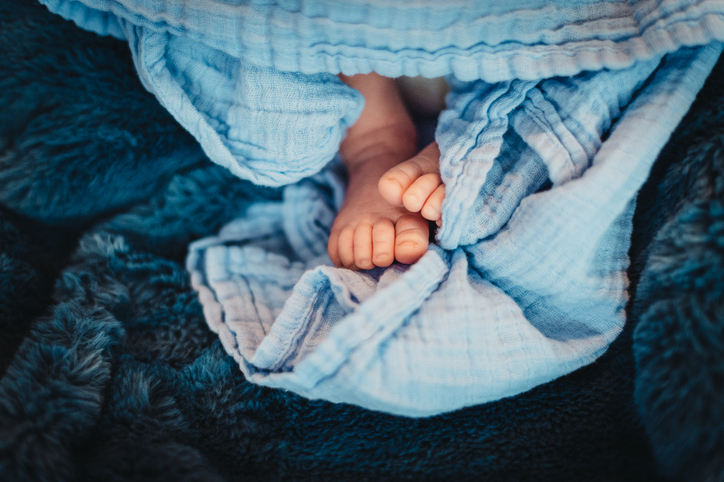 Closeup newborn baby boy feet on blue blanket