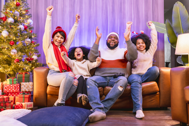 African american family happiness cheering embracing celebrating goal while watching sports on TV at home ,family spending time together at christmas holiday vacation