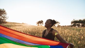 LGBTQ+ pride, woman holding a rainbow flag