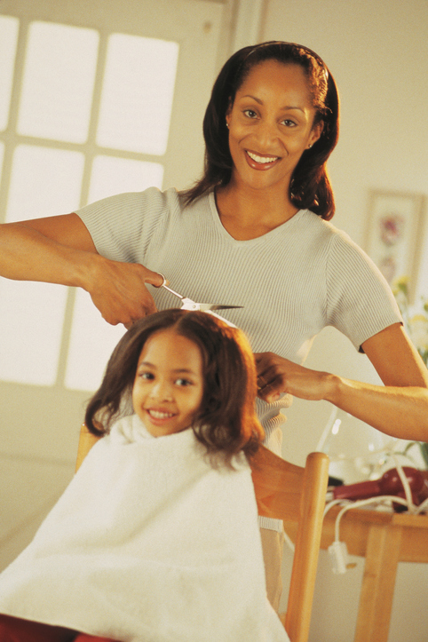 Mother giving daughter a haircut