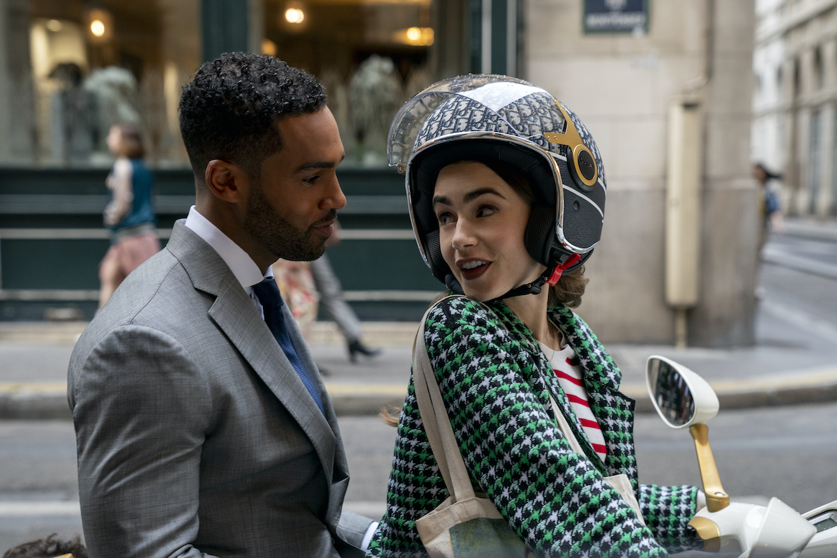 Emily In Paris production stills featuring Lucien Laviscount as Alfie and Lily Collins as Emily enjoying a romantic scooter ride