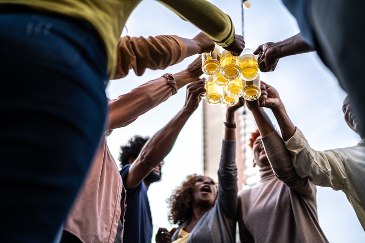 Friends doing a celebratory toast with beer during happy hour