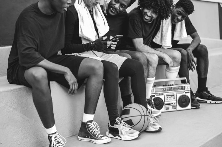 Group of young african people listening music outdoor after basketball match - Focus on ball - Black and white editing