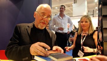 Brazilian author Paulo Coelho (L) signs...
