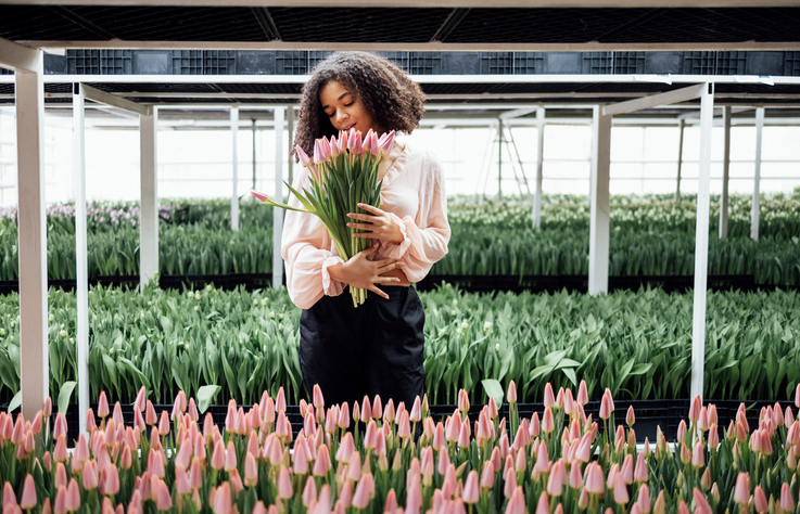 Beautiful romantic smiling african ethnicity girl holding bouquet