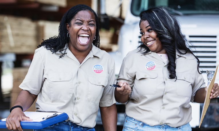 Black women working at lumberyard, with I Voted stickers