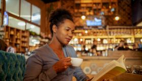 Escaping Into a Story: A Woman Deep in a Book at a Peaceful Coffee Shop