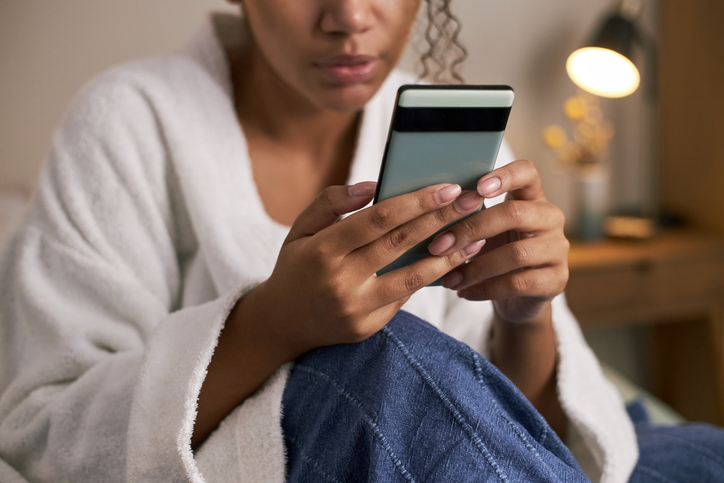 Young Adult Black Woman Using Smartphone While Chatting on Dating Application
