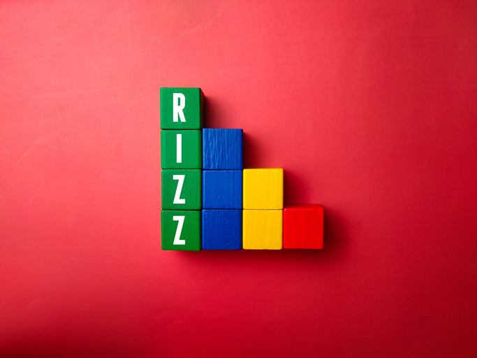 Colored wooden block with word RIZZ. A slang word that means a person's charisma or attractiveness in the context of attracting a partner romantically
