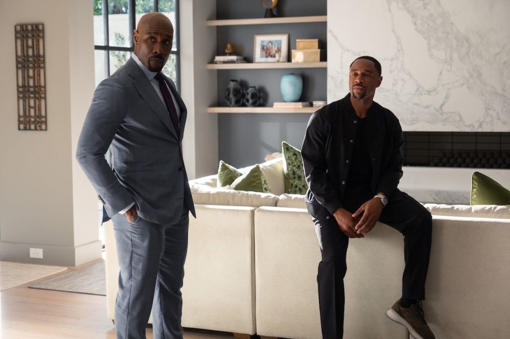 Reasonable Doubt, Morris Chestnut in a suit and Tank in a black shirt, standing and sitting in a modern living room setting.